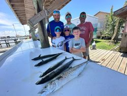 A group of 6 people fishing in the Gulf Shores of Alabama, catching a King Mackerel
