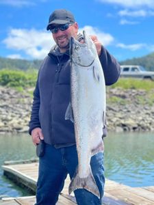 A fisherman holds a coho salmon in Tillamook