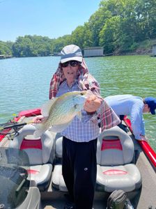 A person holding a 15-inch fish while fishing in GA