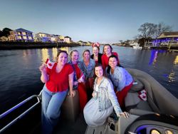 Group enjoying boat outing on waterway in North Myrtle Beach SC with waterfront homes in background