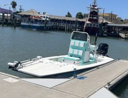 Fishing boat docked at marina in Port Aransas TX with outboard motor and fishing equipment