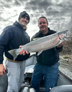 A fisherman with a large rainbow trout caught while fishing in Brookings