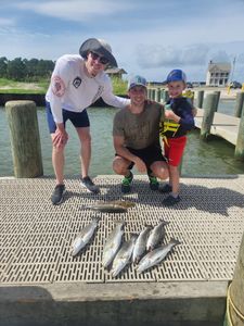 Fresh caught speckled trout and American eel displayed on dock after successful fishing trip in Gulf Shores AL