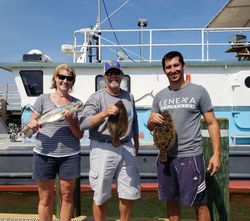 Successful fishing trip in Gulf Shores AL with speckled trout and summer flounder catch displayed on dock