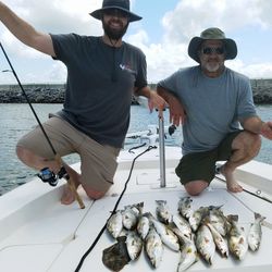 Successful fishing trip in Gulf Shores AL with large catch of speckled trout and redfish on boat deck