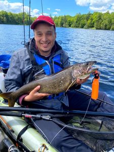 Angler with a large lake trout caught while fishing in ON