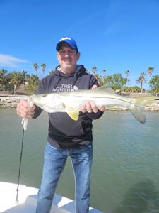 A successful angler with a large snook fish in FL