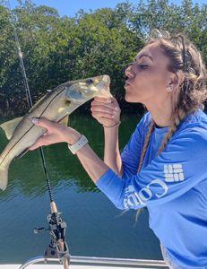 A photograph of an angler holding a snook fish caught in Sarasota.