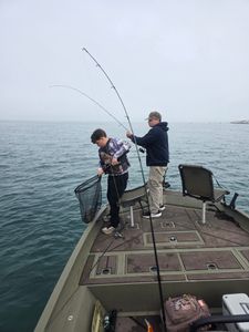 Fishing from boat deck on calm waters in Elma New York with fishing rod extended