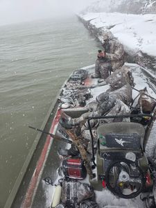 Ice fishing scene in snowy conditions with fishing equipment and gear set up on frozen surface in Elma New York