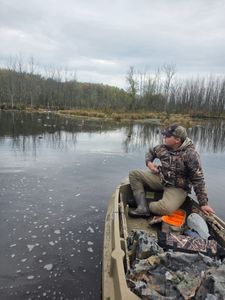 Duck hunting in icy water with decoys scattered across frozen lake surface in Elma New York