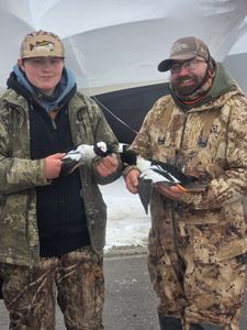 Two hunters displaying harvested waterfowl during hunting trip in Elma New York