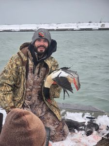 Hunter displaying harvested waterfowl during hunting trip in Elma New York