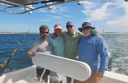 Four people fishing on the beach in Panama City Beach