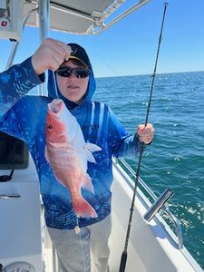 Angler holding a 14-inch fish on the beach in Panama City Beach