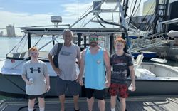 Four people standing on dock with fishing boat at Port Canaveral FL marina