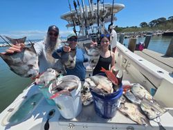 Successful fishing trip in Gulf Shores AL with large catch displayed on boat deck