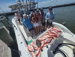 Successful fishing trip in Gulf Shores AL with large catch of red snapper displayed on boat deck