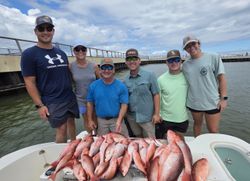 Successful red snapper fishing trip in Gulf Shores AL with large catch displayed on boat