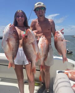 Four red snapper caught during Gulf Shores Alabama fishing trip displayed on boat deck