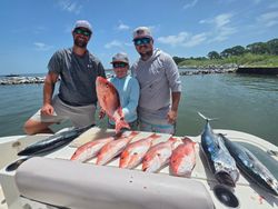 Successful fishing trip in Gulf Shores AL with fresh caught red snapper and other fish displayed on boat