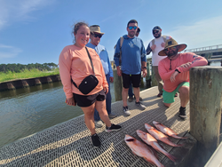 Reeling in a Red Snapper on a partly cloudy day in Gulf Shores!