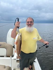 A fisherman holding a 16-inch redfish in LA