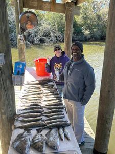 Two anglers with a black drum and spotted weakfish in Hopedale