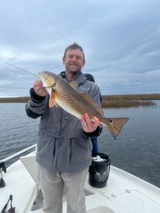 Angler holding a large redfish catch in LA