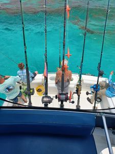 Deep sea fishing charter boat with multiple fishing rods set up over turquoise waters in Fort Walton Beach FL