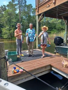 Three anglers displaying freshly caught blackfin tuna on wooden dock in Fort Walton Beach FL