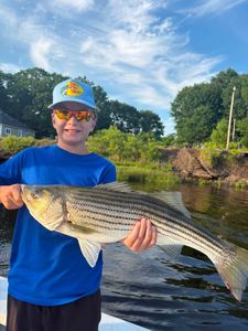 Striped bass catch displayed over water in Old Orchard Beach ME