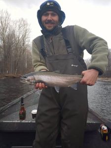 Angler holding a 16-inch rainbow trout in Altmar