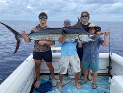Four people fishing for an Atlantic Sailfish in FL