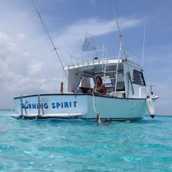 Fishing boat Morning Spirit anchored in crystal clear turquoise waters in Cayman Islands