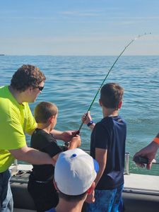 Fishing charter in Port Clinton OH with bent fishing rod indicating fish on the line