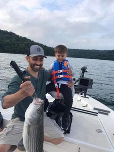 Striped bass fish caught by two people in Garfield