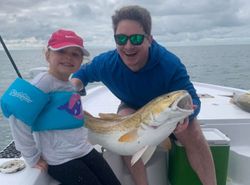 Two anglers with a small, unidentified catch in Orange Beach