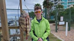 A fisherman holding a 19-inch fish in AL
