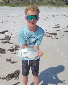 A fisherman holding a Florida Pompano fish in FL.