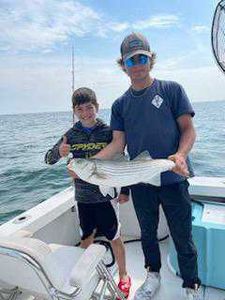Anglers standing in water with fishing rods in MA