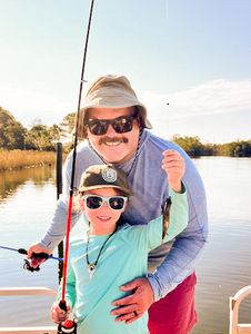 Fishing trip on calm water in Bagdad FL with fishing rod and boat