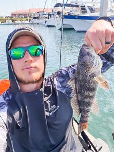 Angler holding caught fish at marina in Bagdad FL