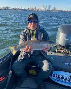 Angler holding a large rainbow trout in Clarkston