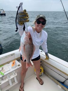 Angler holding a grey snapper fishing in FL