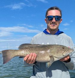 A person fishing in Clearwater with a 22-inch catch