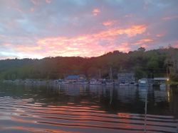 Marina harbor at sunset with boats moored in calm water in Connelly NY