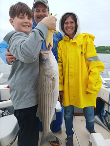 Happy anglers with a big striped bass catch!