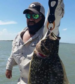 A fisherman holding a Pacific Halibut in TX