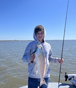 Redfish hooked by kid in Port Aransas fishing